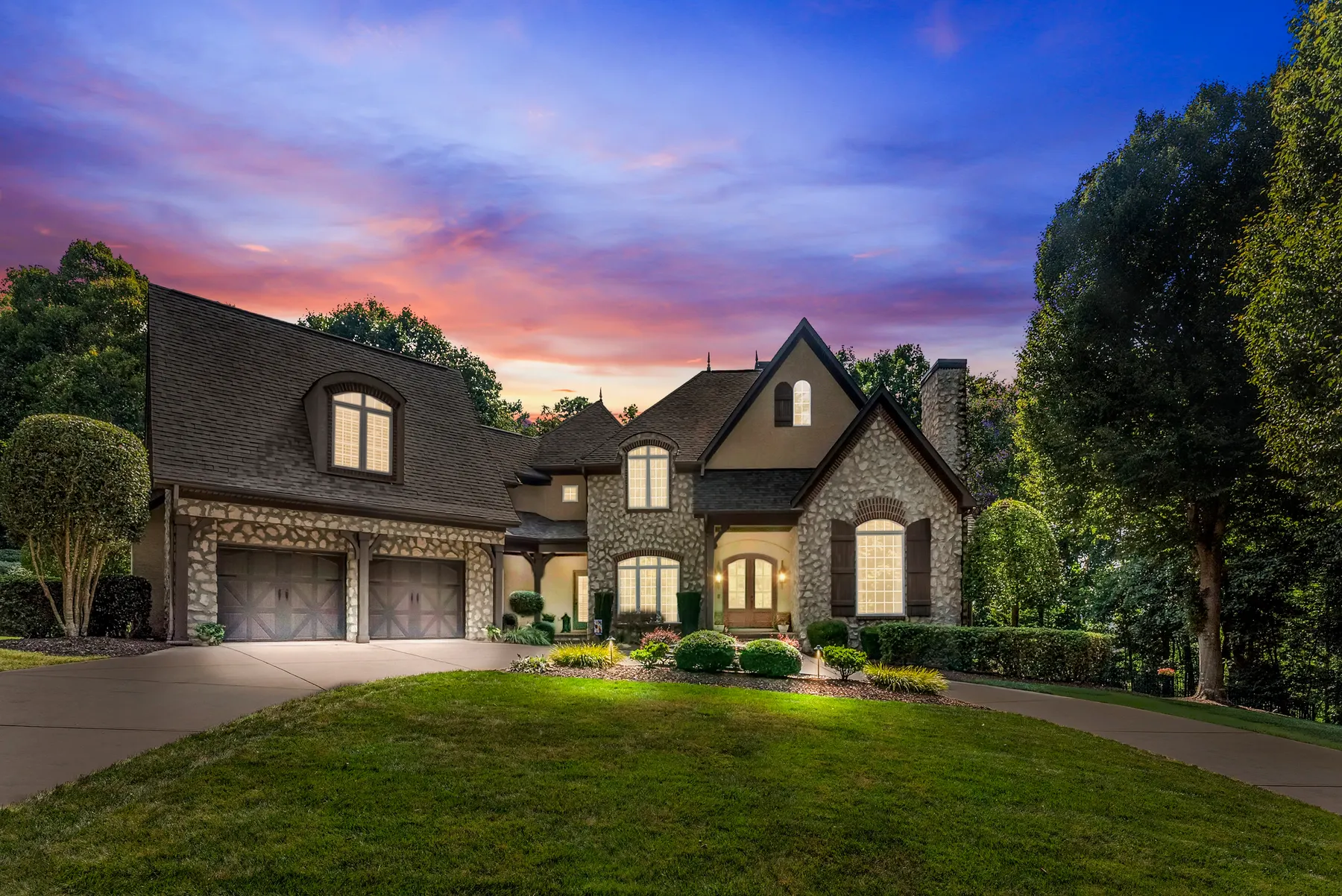 Stone house at twilight with warm lights in every window